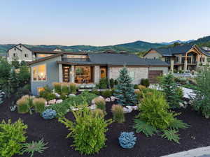 View of front of property with a mountain view, a porch, and a garage