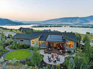 Back house at dusk featuring a water and mountain view and a fire pit