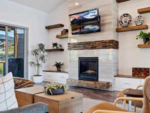 Living room with light hardwood / wood-style floors and a tiled fireplace