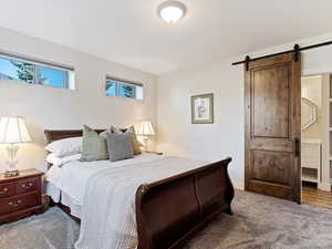 Bedroom with carpet flooring and a barn door