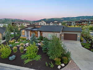 View of front of home with a mountain view and a garage