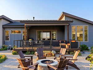 Rear view of house with a patio, an outdoor fire pit, and a wooden deck