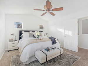 Bedroom featuring ceiling fan, light carpet, and vaulted ceiling