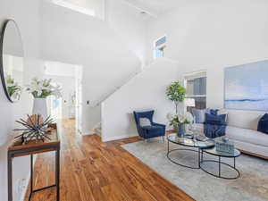 Living room with a high ceiling and hardwood / wood-style floors