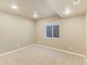 Carpeted spare room featuring a textured ceiling