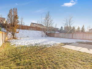 Yard covered in snow with a patio area