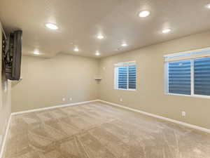 Unfurnished room with carpet and a textured ceiling