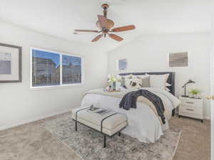 Bedroom with ceiling fan, lofted ceiling, and light carpet