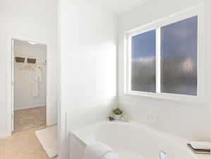 Bathroom with tile patterned flooring and a tub