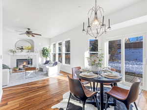 Dining space featuring ceiling fan, light hardwood / wood-style flooring, plenty of natural light, and a tiled fireplace