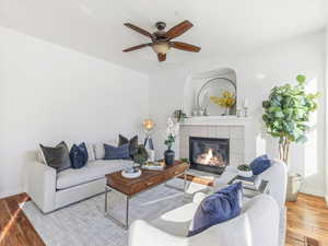 Living room with a fireplace, hardwood / wood-style flooring, and ceiling fan