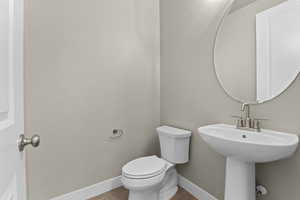 Bathroom with sink, hardwood / wood-style floors, and toilet