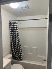 Full bathroom with vanity, toilet, and shower / bathtub combination with curtain