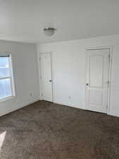 Unfurnished room with dark colored carpet