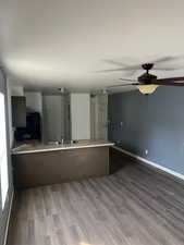 Kitchen featuring hardwood / wood-style flooring, refrigerator, kitchen peninsula, and sink