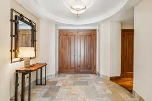 Foyer featuring a tray ceiling and light hardwood / wood-style flooring