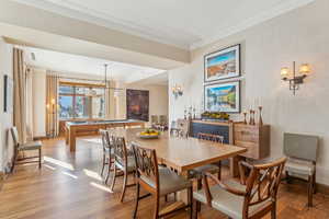 Dining space with wood-type flooring, crown molding, and pool table