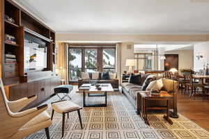 Living room with light wood-type flooring and a notable chandelier