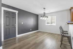 Unfurnished dining area featuring a chandelier and light wood-type flooring