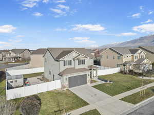 View of front of house with a mountain view, a front lawn, and a garage