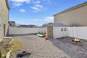 View of yard featuring a shed and a fire pit