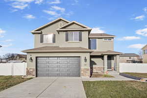 Front of property with a garage and a front lawn