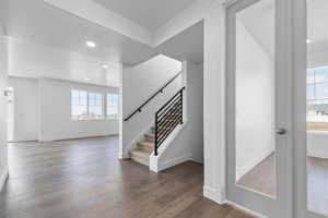 Staircase with recessed lighting, baseboards, and hardwood / wood-style floors