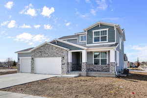 Craftsman house featuring central air condition unit, an attached garage, concrete driveway, and stone siding