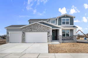 Craftsman house featuring an attached garage, stone siding, driveway, and a shingled roof