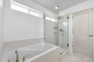 Full bath with a bath, marble finish floor, a stall shower, and a textured ceiling