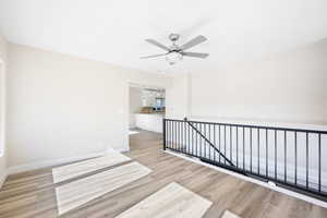 Empty room with ceiling fan and light hardwood / wood-style floors