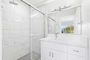 Bathroom featuring a shower with door and vanity