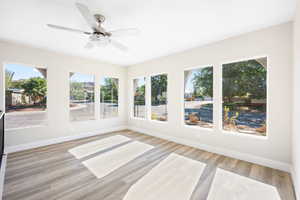 Unfurnished sunroom with ceiling fan