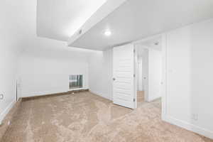 Additional living space featuring a textured ceiling and light carpet