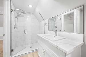 Bathroom with vanity, an enclosed shower, and wood-type flooring