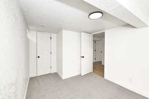 Interior space featuring light carpet and a textured ceiling