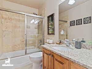 Full bathroom featuring vanity, toilet, and enclosed tub / shower combo