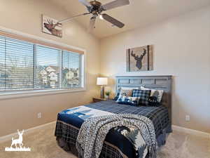 Bedroom featuring ceiling fan, light carpet, and vaulted ceiling