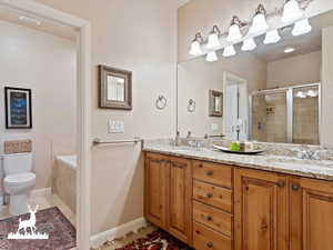 Full bathroom with tile patterned flooring, vanity, toilet, and shower with separate bathtub