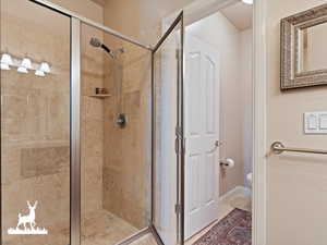 Bathroom featuring tile patterned floors, toilet, and walk in shower