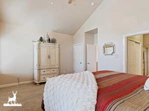 Carpeted bedroom with ceiling fan and high vaulted ceiling