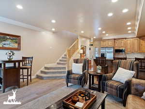 Living room featuring crown molding and light hardwood / wood-style flooring