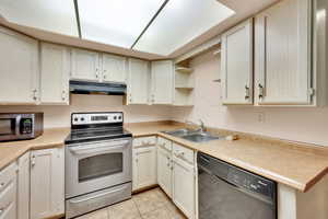 Kitchen featuring sink, light tile patterned flooring, and appliances with stainless steel finishes