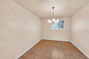 Tiled empty room with a chandelier