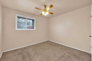 Carpeted spare room with ceiling fan