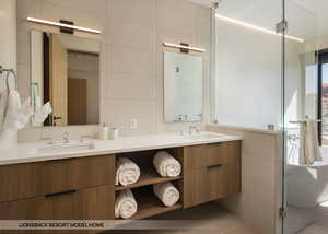 Bathroom with tile patterned flooring, vanity, and tile walls