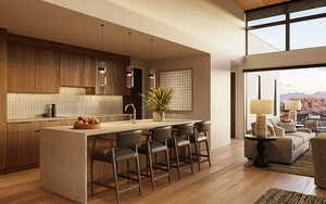 Kitchen with decorative backsplash, sink, a towering ceiling, and light hardwood / wood-style floors