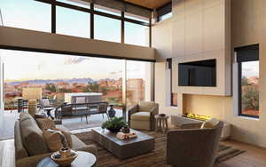 Living room with a high ceiling, dark hardwood / wood-style floors, a healthy amount of sunlight, and a tiled fireplace