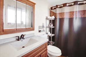 Bathroom with a shower with shower curtain, vanity, and toilet