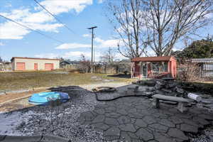 View of patio / terrace featuring an outbuilding and an outdoor fire pit